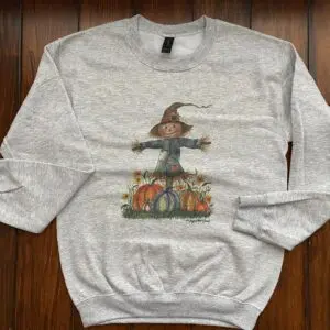 Autumn-themed sweatshirt on wooden floor