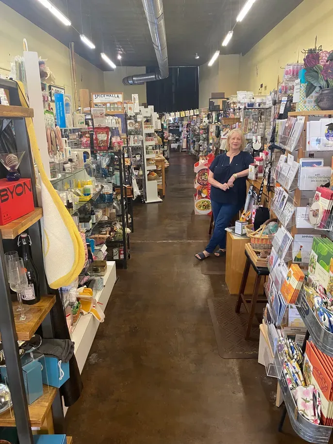 Woman standing in crowded gift shop aisle