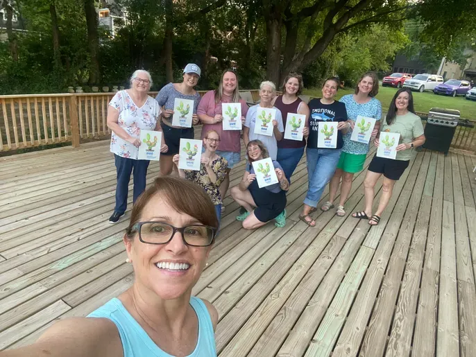 Woman taking selfie with group holding certificates