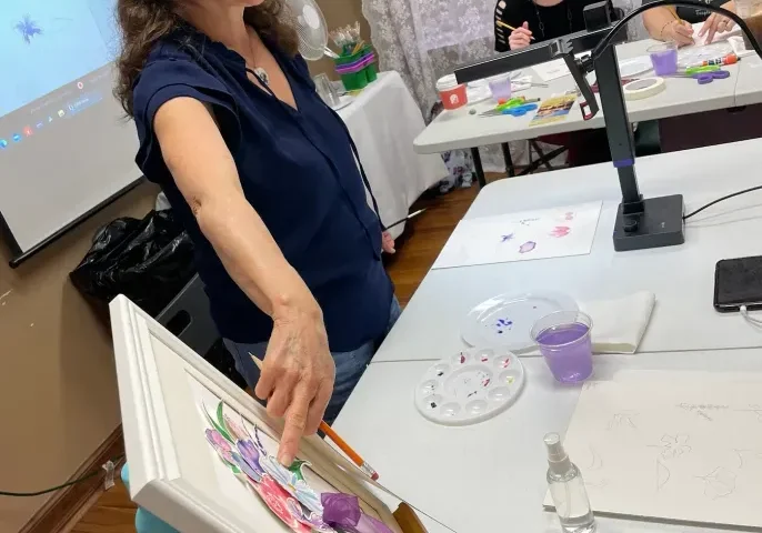 Art instructor teaching painting class with students