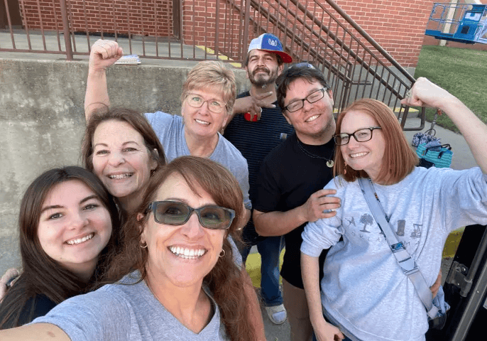 Smiling group selfie outside brick building